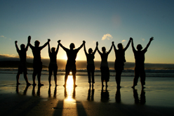 Group of people joined with hands lifted high