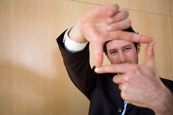 Man looking through frame made using his fingers